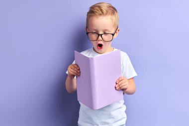 Elinde kitap tutan süpriz çocuk. Eğitim portresi kavramı