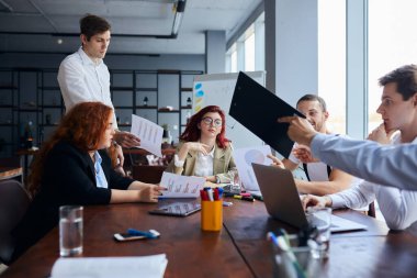 İş adamları yaratıcı ofisteki toplantı odasında tartışıyor.