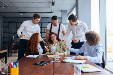 Ofiste kadın liderin yanında mutlu bir iş ekibi var.