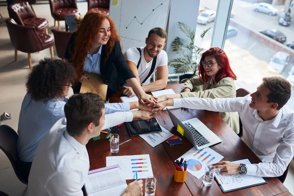 Equipe de negócios caucasiana juntando as mãos no escritório moderno — Fotografia de Stock