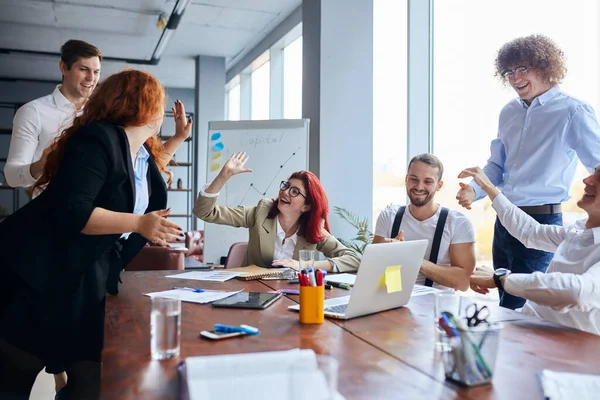 Glad att vara en del av ett kreativt team. Grupp glada affärsmän på plats på bordet — Stockfoto