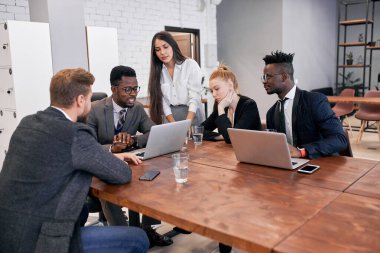 African businessman speaking with his multi-ethnic team in modern office