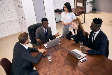 Afrikalı Amerikalı iş adamı genç iş adamlarıyla konuşuyor.