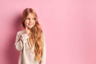 Hayalperest kız yeni bir oyuncak bebek düşünüyor.