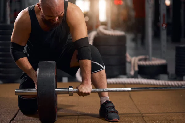 Powerlifter changing iron discs in gym — Stock Photo, Image