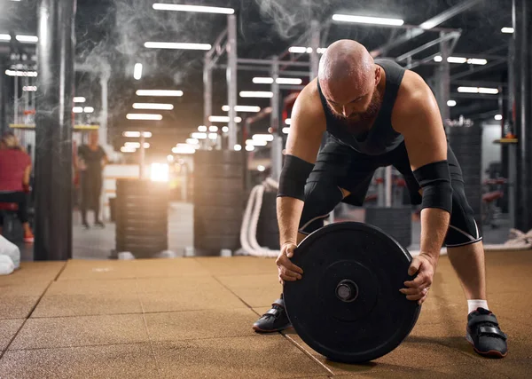 Powerlifter byta järn skivor i gymmet — Stockfoto