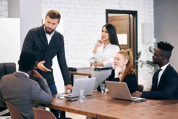 Sträng kaukasisk man i smoking med sitt affärsteam — Stockfoto