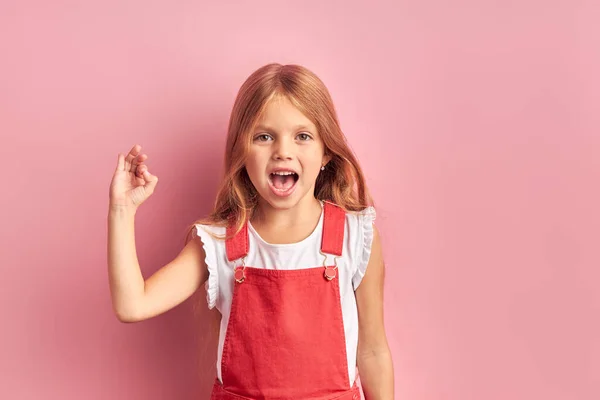 Vicces kislány nyitott szájjal elszigetelt felett rózsaszín háttér — Stock Fotó
