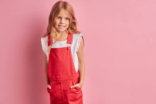 Retrato de niña sonriente con el pelo largo sobre fondo rosa —  Fotos de Stock