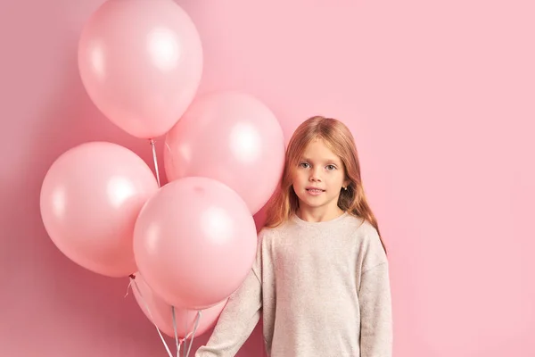 Menina bonita tímida garoto segurando balões de ar rosa isolado — Fotografia de Stock