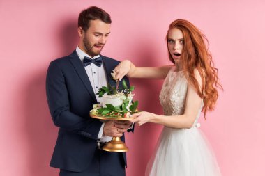 Pasta tutan şaşırmış bir adam ve yalnız elbiseli bir kadın.