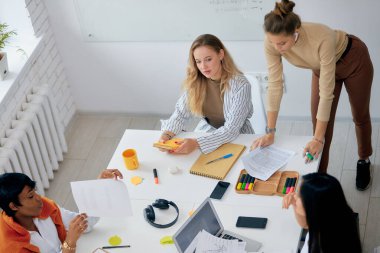 Ofiste çalışan Afrikalı ve beyaz kadınlar.