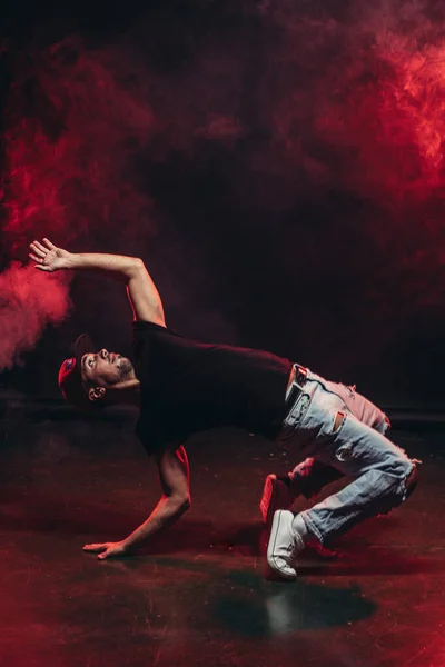 Atlético hombre bailando aislado en humo fondo — Foto de Stock