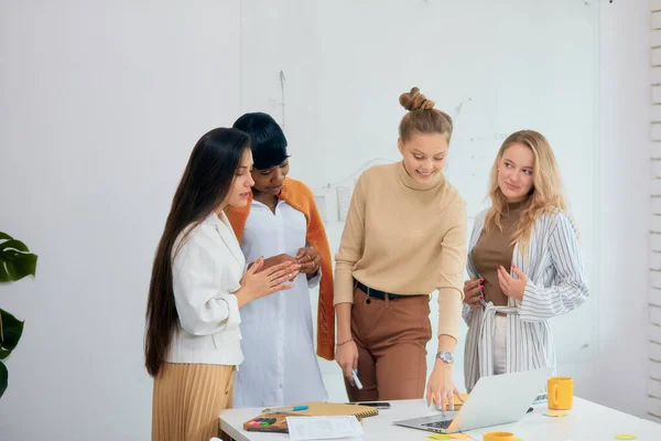 Multi-ethnic business team coworking in office on laptop — Stock Photo, Image