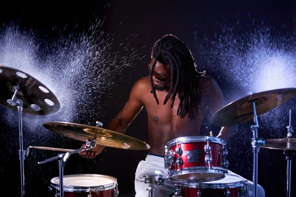 Perkusista czarny mężczyzna muzyk uderzając na mokry bęben talerz i woda plusk w zwolnionym tempie — Zdjęcie stockowe