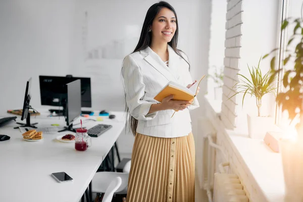 Retrato de hermosa mujer de negocios joven caucásica con libro en la oficina — Foto de Stock