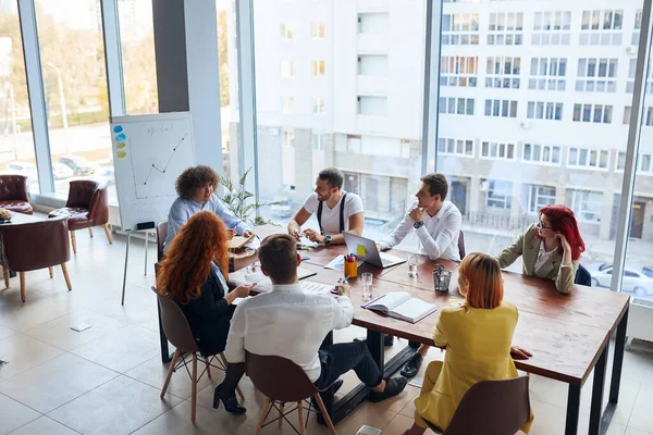 Менеджеры бизнес-команды обсуждают бизнес-идеи во время встречи в офисе — стоковое фото