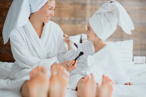 Mother and daughter legs on bed close-up — Stock Photo, Image