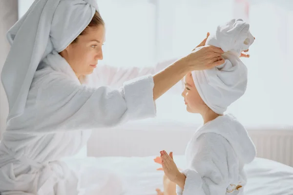 Careful attentive woman straightens a towel to daughter — Stock Photo, Image