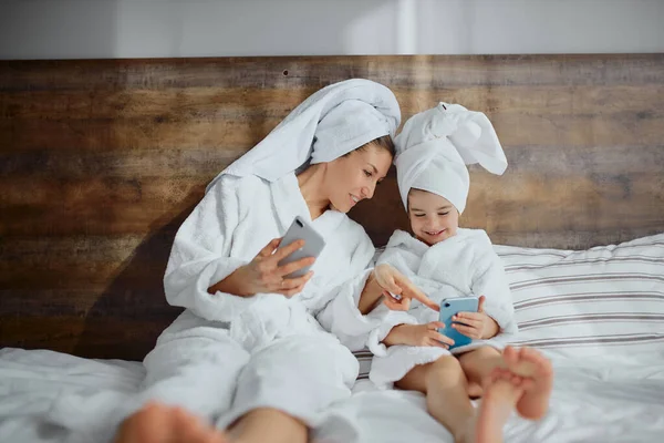 Female in bathrobe spend time with daughter after shower — Stockfoto