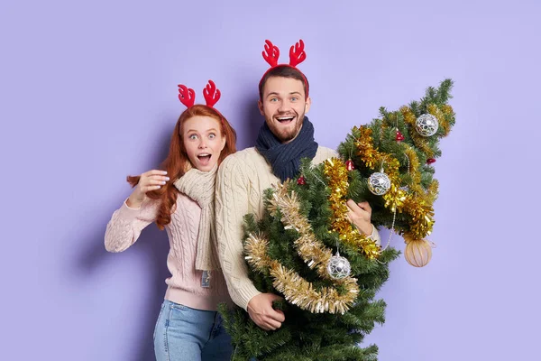 Glada par i festligt rum vid julgranen — Stockfoto