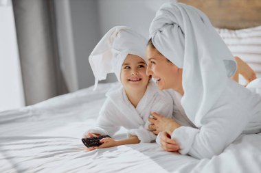 Güzel beyaz anne ve kızı TV izleyecek.