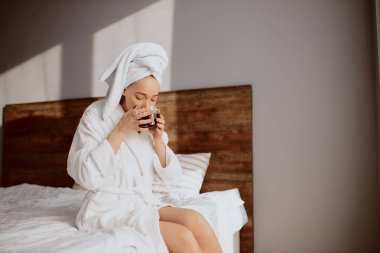 Otel odasında kahve içen hoş bir kadın.