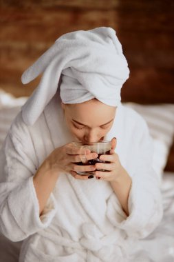 Güzel kadın banyodan sonra sıcak kahve içiyor.