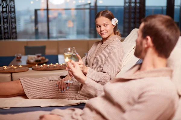 Молодая супружеская пара в спа-салоне пьет шампанское — стоковое фото