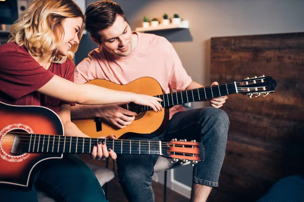 Dwóch młodych białych ludzi zrelaksować spędzać czas razem, gra na gitarze — Zdjęcie stockowe