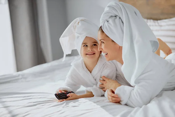 Красива біла мати і дочка збираються дивитися телевізор — стокове фото