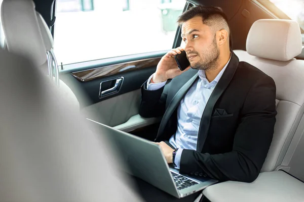 Elfoglalt férfi beszél telefonon autóban — Stock Fotó