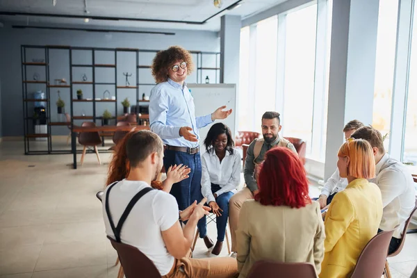 Smiling caucasian businessman make presentation to leaders, co-workers