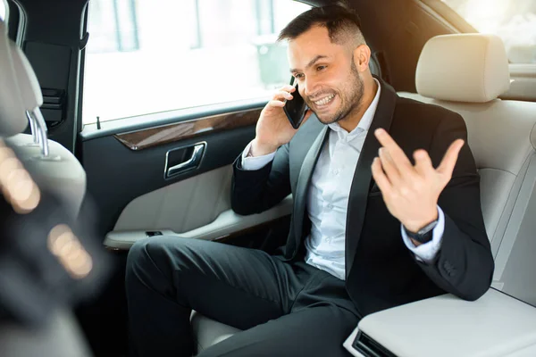 Fiatal üzletember beszél telefonon kollégájával vezetés közben — Stock Fotó