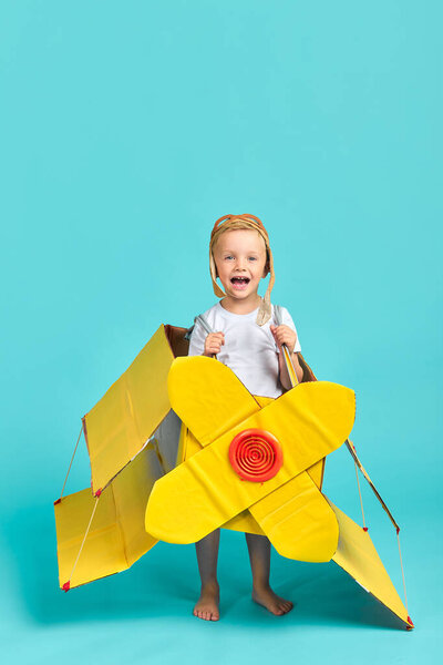 Радостное кавказское дитя в желтой игрушечной плоскости
