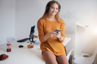 Neşeli iş kadını iş yerinde rahatla. Kameraya bak.