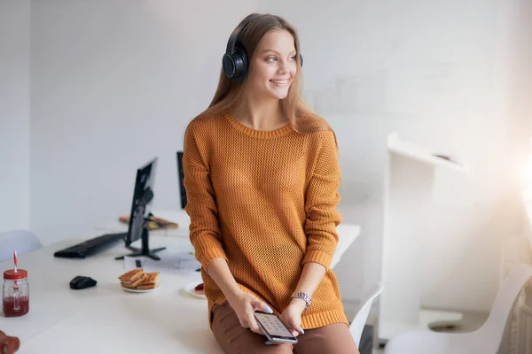 Wanita bisnis muda mendengarkan musik pada waktu luangnya di kantor — Stok Foto