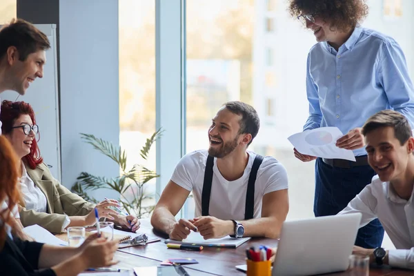 Glad att vara en del av ett kreativt team. Grupp glada affärsmän på plats på bordet — Stockfoto