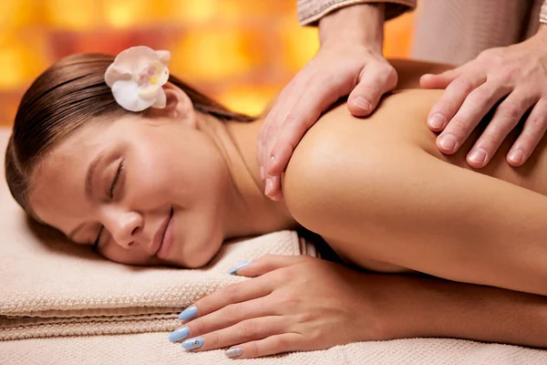 Massagista profissional caucasiano fazendo massagem de mulher de volta no salão de beleza — Fotografia de Stock