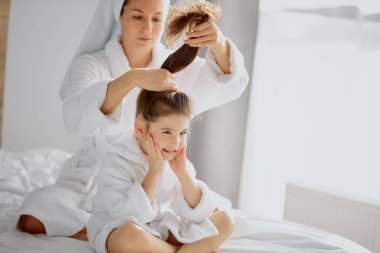 Sevimli anne ve kızı duştan sonra yatakta.