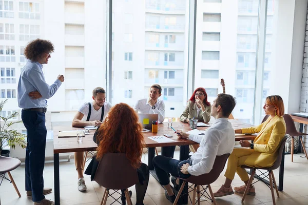 Joven líder masculino dando discurso a jóvenes compañeros de trabajo —  Fotos de Stock