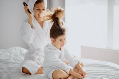 Dikkatli kadın ebeveyn saçlarını tarıyor.