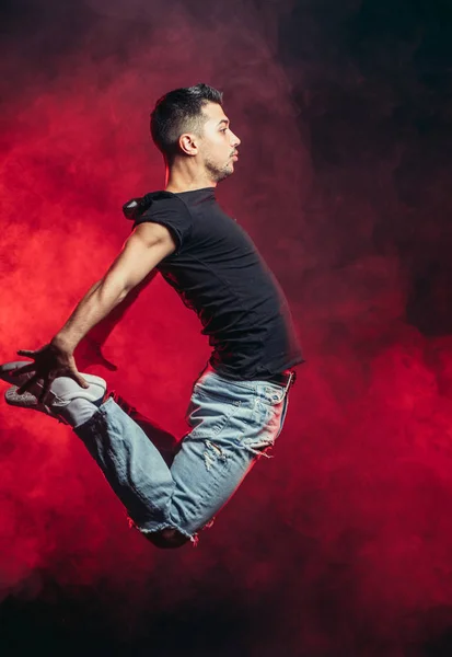 Hombre bailarín vigoroso en el aire aislado sobre el espacio ahumado —  Fotos de Stock