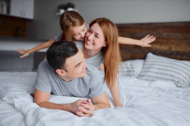 Mutlu bir aile gibi evde yatakta gülümsüyoruz.