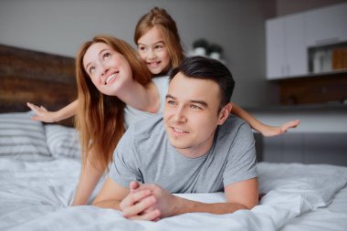 Sevimli ebeveynler ve küçük tatlı kızları yataktalar.