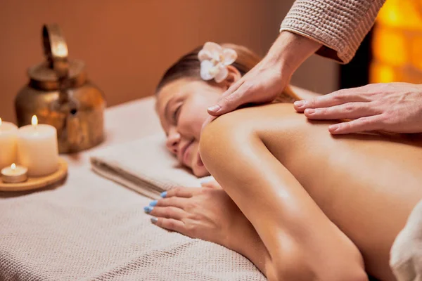Relajada mujer caucásica recibiendo masaje de espalda en el salón de spa —  Fotos de Stock