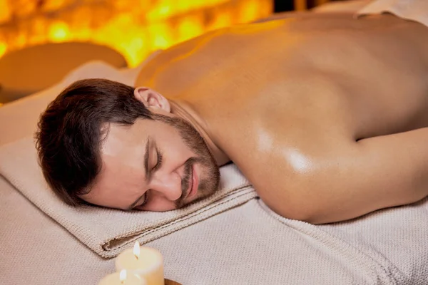 Caucásico hombre acostado en mesa de masaje y relx —  Fotos de Stock