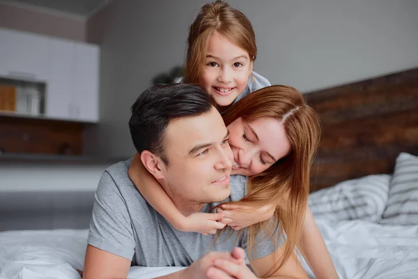 Mutlu bir aile gibi evde yatakta gülümsüyoruz. — Stok fotoğraf