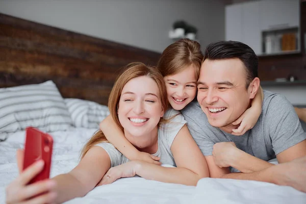 Temps libre de la famille caucasienne couché sur le lit — Photo