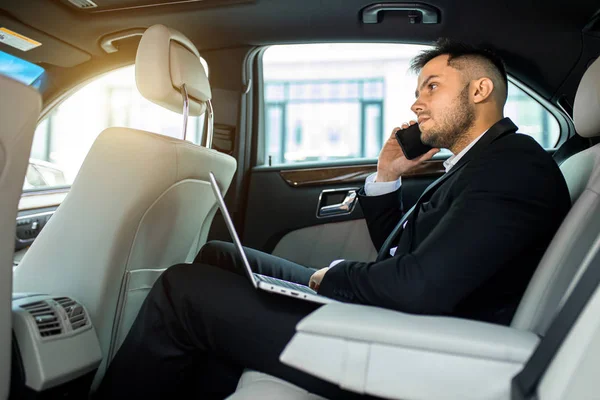Elfoglalt férfi beszél telefonon autóban — Stock Fotó